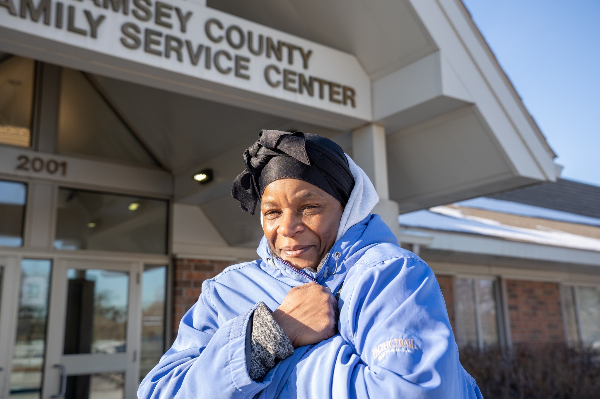 A Black woman wearing a winter coat outside of the Ramsey County services center